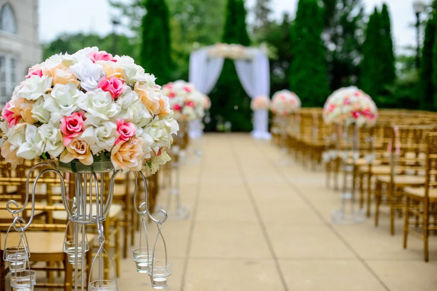 An empty wedding aisle with flowers in focus at the forefront and a marriage altar out of focus in the background.